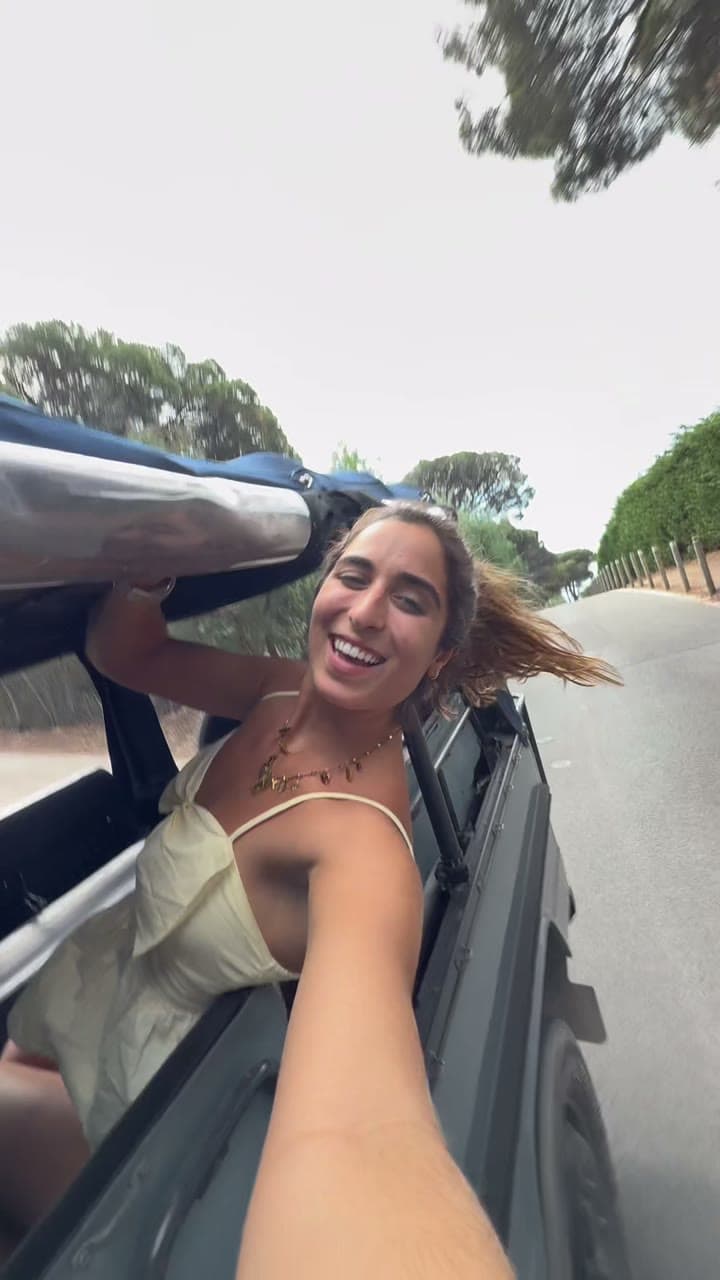 Makenna laughing in a convertible on the coast of St. Tropez